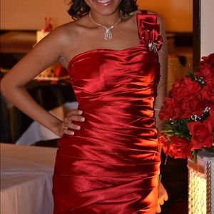 One shoulder red dress with jeweled adornments.